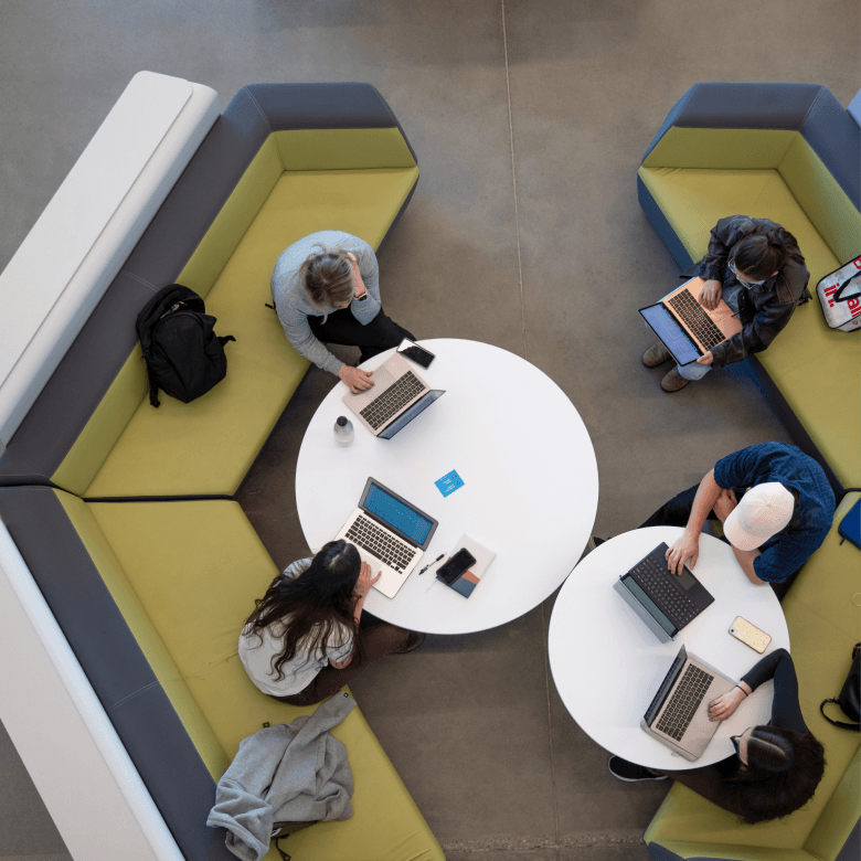 A view of students working on laptops from above.