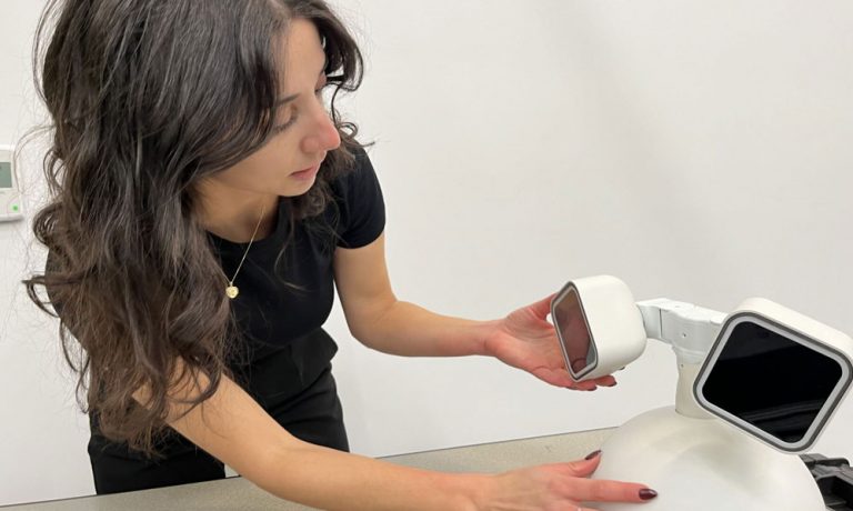 Student researcher working with a robot.